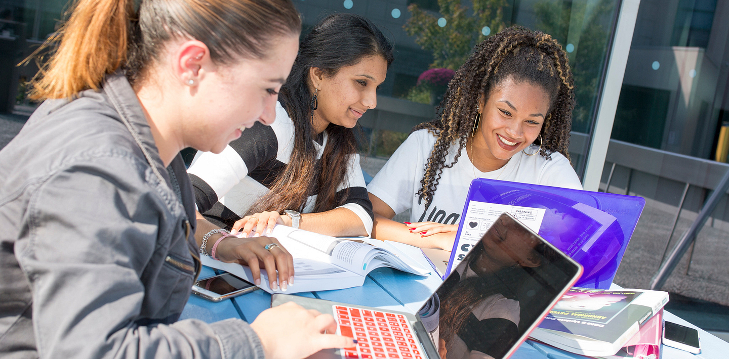 picture of Centennial College International Education students working together at a picnic table in the Progress Campus courtyard